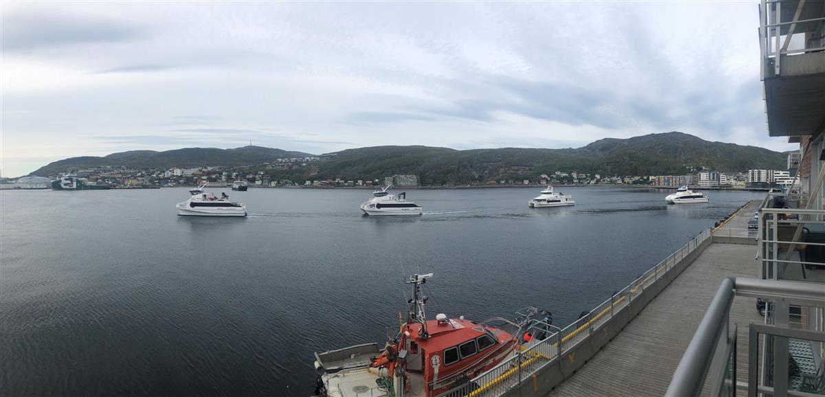 Fire hurtigbåter (kombibåt: passasjer og bil) er på vei ut fra Hammerfest havn. Bildet er tatt på sommerhalvåret. Det er overskyet. - Klikk for stort bilde